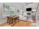 Bright living room featuring a fireplace, a ceiling fan, hardwood floors, and a dining area at 1830 Wickford Pl, Charlotte, NC 28203