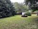 Spacious backyard with mature trees, shed, and a brick firepit, perfect for outdoor gatherings at 2009 Hickory Grove Rd, Gastonia, NC 28056