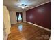 Spacious bedroom boasts hardwood floors, a ceiling fan, and a large window with decorative curtains at 2009 Hickory Grove Rd, Gastonia, NC 28056