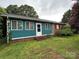 Charming single-story home with a brick foundation and teal siding, complemented by well-manicured landscaping at 2009 Hickory Grove Rd, Gastonia, NC 28056