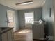 Bright laundry room features modern washer and dryer with a door to the outside and wood-look flooring at 2009 Hickory Grove Rd, Gastonia, NC 28056