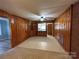 Spacious living room with wood paneled walls, tile floor and view to kitchen at 2009 Hickory Grove Rd, Gastonia, NC 28056