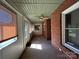 Enclosed porch with brick walls, open windows, and ceiling fan with door to the outside at 2009 Hickory Grove Rd, Gastonia, NC 28056