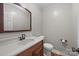 Well-lit half bathroom with wood vanity and a modern countertop at 201 Scalybark Trl, Concord, NC 28027