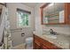 Bathroom showcasing granite vanity, wood cabinets, and a bright window view at 201 Scalybark Trl, Concord, NC 28027