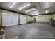Spacious garage with multiple doors, lighting, and ample workspace at 201 Scalybark Trl, Concord, NC 28027