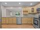 Well-lit kitchen features stainless steel appliances, granite countertops, and honey colored cabinetry with a wood floor at 201 Scalybark Trl, Concord, NC 28027