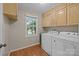 Functional laundry room with built-in cabinets, hardwood floors and large windows for natural light at 201 Scalybark Trl, Concord, NC 28027