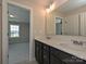 Modern bathroom with double sink vanity and a view into the carpeted bedroom at 2046 Sabra St # Cwo0006, Gastonia, NC 28054