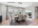 A dining room with a wooden table, six chairs, a modern light fixture and three windows with blinds at 2046 Sabra St # Cwo0006, Gastonia, NC 28054