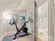 Attic exercise room open to an ensuite bathroom, featuring a Peloton bike and natural light at 2432 Hassell Pl, Charlotte, NC 28209