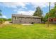 View of the backyard featuring a gray home with a green lawn and an outdoor patio at 2511 Linwood Rd, Gastonia, NC 28052