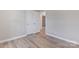 Clean neutral bedroom with wood-look floors and interior door for en-suite access at 2511 Linwood Rd, Gastonia, NC 28052