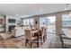 Open-concept living/dining area with fireplace, large windows, and access to patio at 2517 Mabel Ln, Monroe, NC 28110