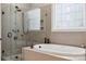 Bright bathroom with standalone shower and soaking tub with decorative leaded-glass window at 309 Palm Cove Way, York, SC 29745