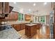 Bright kitchen showcasing granite countertops, wooden cabinets, tile backsplash, and a center island with cooktop at 309 Palm Cove Way, York, SC 29745