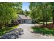 Inviting single-story home with lush greenery, a circular driveway, and attached two-car garage at 327 Wilby Dr, Charlotte, NC 28270
