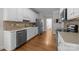 Well-maintained kitchen featuring stainless appliances, white cabinetry, and wood flooring at 327 Wilby Dr, Charlotte, NC 28270