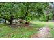 Natural backyard setting with mature trees, a small outbuilding, and ample space for outdoor activities at 3700 Nevin Rd, Charlotte, NC 28269