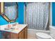 Quaint bathroom with blue walls, vanity with sink, and shower with decorative curtain at 3700 Nevin Rd, Charlotte, NC 28269