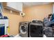 A laundry room featuring a modern, front-load washer and dryer set with overhead cabinet space at 3700 Nevin Rd, Charlotte, NC 28269