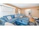 Comfortable living room featuring plush blue sectional, ottoman, and view into other parts of the house at 3700 Nevin Rd, Charlotte, NC 28269