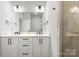 Contemporary bathroom with double vanity, framed mirror, and glass-enclosed shower at 4011 Tundra Rd, Charlotte, NC 28203