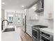 Modern kitchen with stainless steel appliances, white cabinets, quartz countertops, and wood flooring at 4011 Tundra Rd, Charlotte, NC 28203