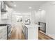 Open concept kitchen with island, stainless appliances, white cabinets, subway tile, and wood floors at 4011 Tundra Rd, Charlotte, NC 28203