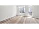 Bright, neutral room with hardwood floors, large window, and access to outdoor balcony at 4011 Tundra Rd, Charlotte, NC 28203