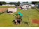 Aerial view of the backyard with a playset and a white storage shed surrounded by lush greenery at 407 Orchard Ln, Belmont, NC 28012