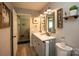 Well-lit bathroom featuring a modern vanity, decorative mirror, and stylish gray cabinetry at 407 Orchard Ln, Belmont, NC 28012