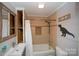 Quaint bathroom featuring a tub with shower, beige tiling, and playful dinosaur decor at 407 Orchard Ln, Belmont, NC 28012