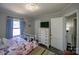 Bright bedroom featuring a comfortable bed, white dresser, and wood-look flooring at 407 Orchard Ln, Belmont, NC 28012