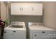 Bright laundry room features a Maytag washer and dryer, and ample storage cabinets above at 407 Orchard Ln, Belmont, NC 28012