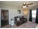 Comfortable living room featuring a leather sofa, ceiling fan, and decorative accents at 407 Orchard Ln, Belmont, NC 28012