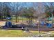 Community playground with slides and swings surrounded by mature trees and lush greenery at 407 Orchard Ln, Belmont, NC 28012