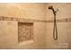Shower detail with decorative beige tiling and a built-in mosaic-tiled niche at 407 Orchard Ln, Belmont, NC 28012