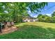 Lush backyard with mature trees, patio area, and swing set at 413 Picadilly Ln, Troutman, NC 28166
