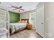Bedroom with wood-look flooring, neutral walls, a bed with a floral quilt, and natural light at 413 Picadilly Ln, Troutman, NC 28166