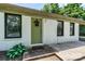 Inviting front entrance with a green door, decorative wreath, and manicured greenery at 413 Picadilly Ln, Troutman, NC 28166