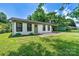 Charming white brick home featuring a welcoming green door and a convenient covered parking area at 413 Picadilly Ln, Troutman, NC 28166