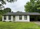 Charming single-story home featuring a carport, freshly painted white brick, and a well-maintained green lawn at 413 Picadilly Ln, Troutman, NC 28166