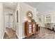 Entry hall featuring wood-look floors, an accent cabinet with a round mirror above, and a view into the living area at 413 Picadilly Ln, Troutman, NC 28166