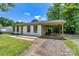 Rear exterior view showcasing the home's carport, white brick, and a well-maintained lawn at 413 Picadilly Ln, Troutman, NC 28166
