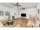 Bright living room featuring hardwood floors, multiple ceiling fans, and neutral-toned sofas at 417 S Broad St, Gastonia, NC 28052