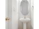 Powder room features pedestal sink, oval mirror, and white walls at 4213 Coulter Xing, Charlotte, NC 28213