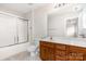 Bathroom featuring wood vanity, framed mirror, white walls, and shower with glass door at 4213 Coulter Xing, Charlotte, NC 28213