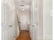 Hallway features wood flooring, white doors, and access to the staircase at 4213 Coulter Xing, Charlotte, NC 28213