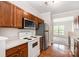 Kitchen featuring stainless steel refrigerator, microwave, stove, wood cabinets and hardwood flooring at 4213 Coulter Xing, Charlotte, NC 28213